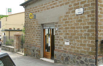 Het postkantoor tegen de muur van het oude centrum van Contignano